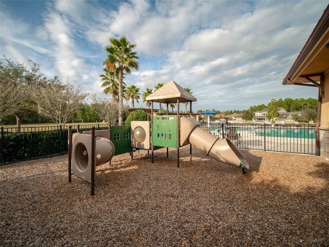 community jungle gym with fence and a community pool