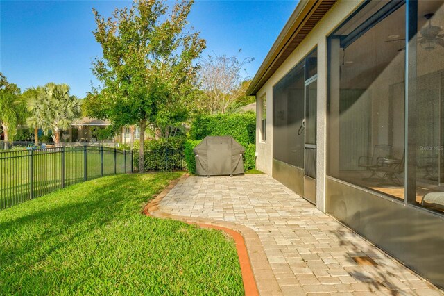 view of yard with a sunroom, a patio area, and a fenced backyard