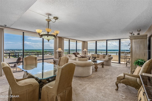 carpeted dining room with a textured ceiling, expansive windows, a water view, and a healthy amount of sunlight