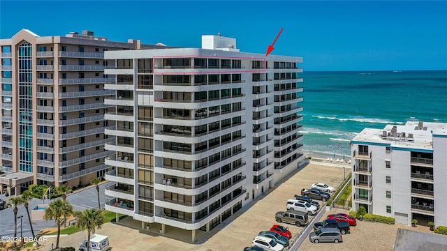 view of building exterior featuring a beach view and a water view