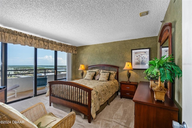 bedroom with a textured ceiling, light carpet, and access to exterior