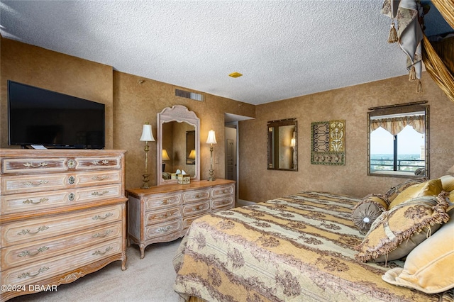 bedroom featuring light colored carpet and a textured ceiling