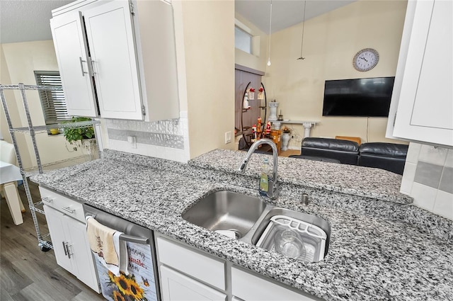 50 Florida Park Dr, Palm Coast, FL 32137 - kitchen with dishwasher, wood finished floors, white cabinetry, and light stone counters