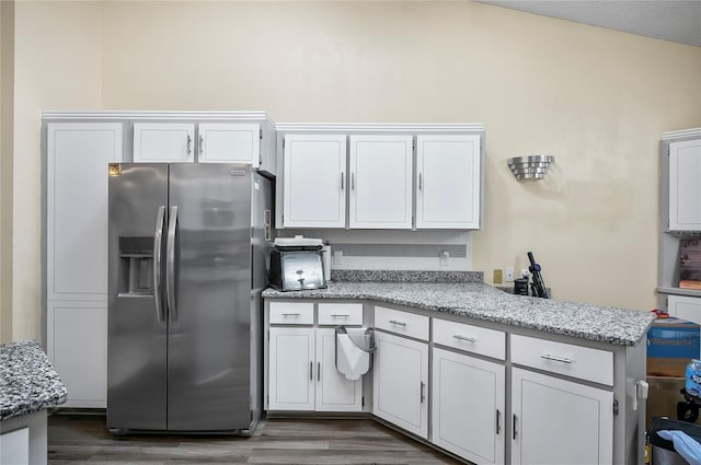 kitchen featuring stainless steel fridge with ice dispenser, white cabinets, and lofted ceiling