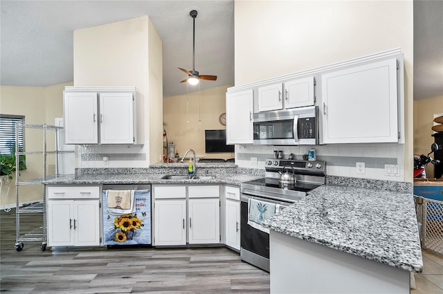 kitchen featuring kitchen peninsula, sink, white cabinets, and stainless steel appliances