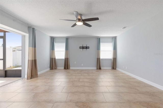 spare room featuring ceiling fan, a textured ceiling, and light tile patterned floors