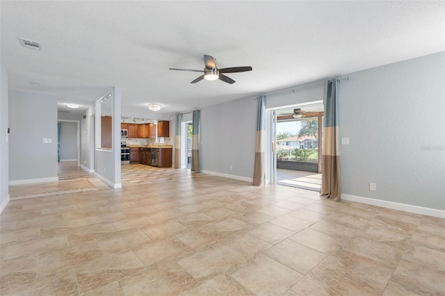 unfurnished living room with a textured ceiling and ceiling fan