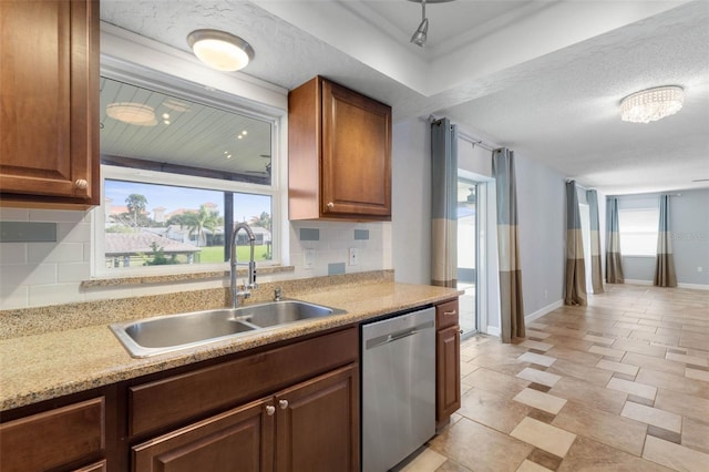 kitchen with dishwasher, decorative backsplash, sink, and a textured ceiling