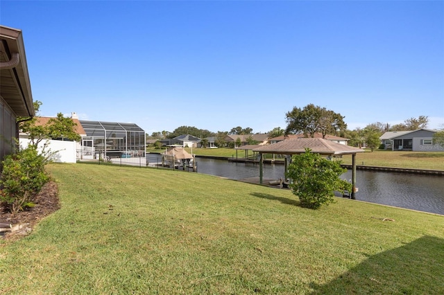 view of yard with a dock, a lanai, and a water view