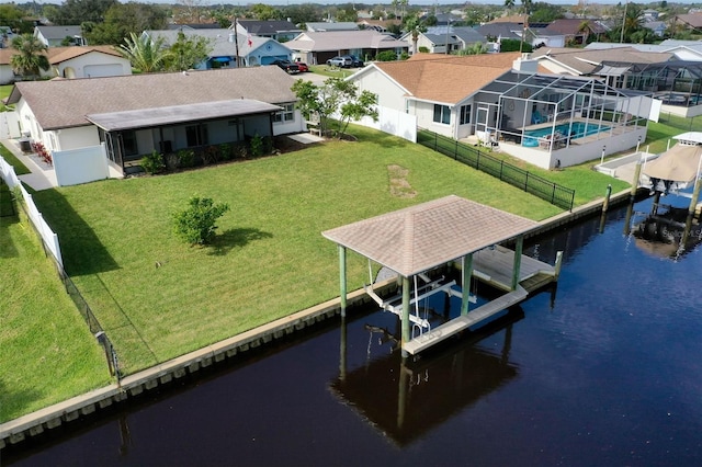 view of dock featuring glass enclosure, a water view, and a yard