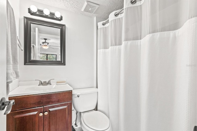 bathroom with vanity, a textured ceiling, and toilet