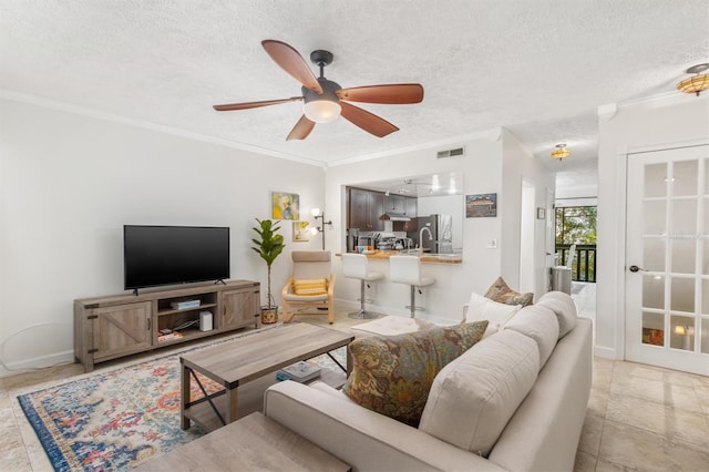 living room featuring a textured ceiling, ceiling fan, and crown molding