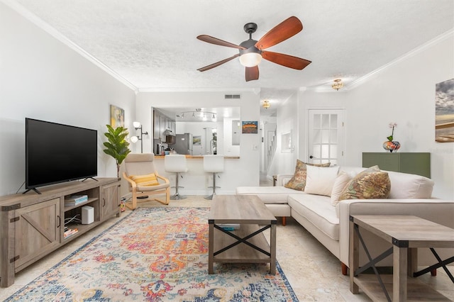 living room with crown molding, ceiling fan, and a textured ceiling