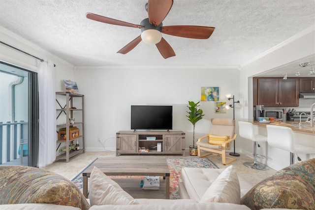 living room featuring crown molding, sink, ceiling fan, and a textured ceiling