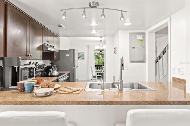 kitchen featuring electric panel, sink, appliances with stainless steel finishes, dark brown cabinets, and a kitchen bar