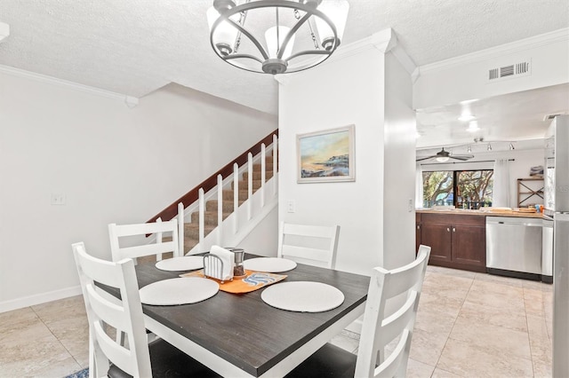 tiled dining room with ceiling fan with notable chandelier, a textured ceiling, track lighting, and ornamental molding