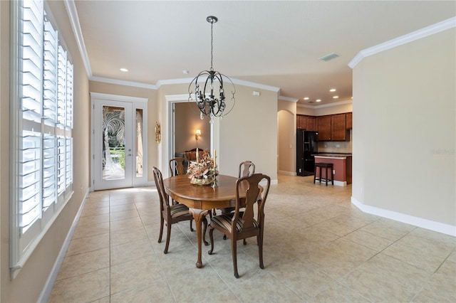 tiled dining space featuring crown molding and a chandelier