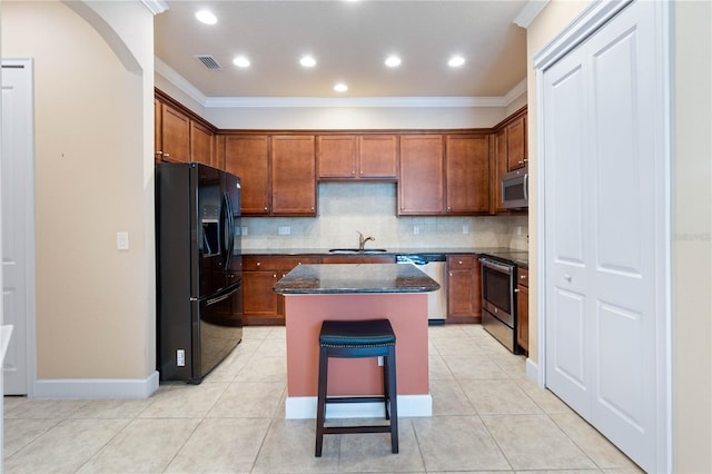 kitchen featuring backsplash, stainless steel appliances, crown molding, sink, and a center island