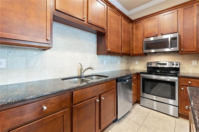 kitchen featuring dark stone countertops, light tile patterned floors, sink, and appliances with stainless steel finishes