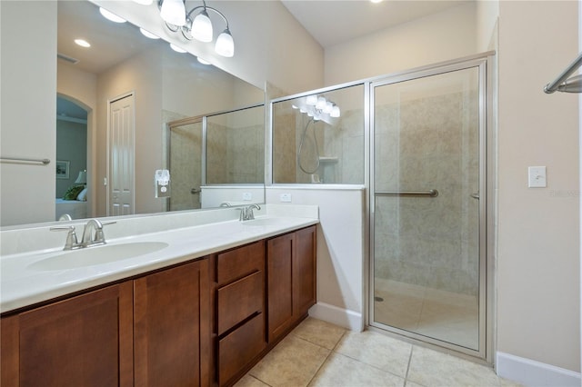 bathroom featuring tile patterned flooring, vanity, and a shower with door