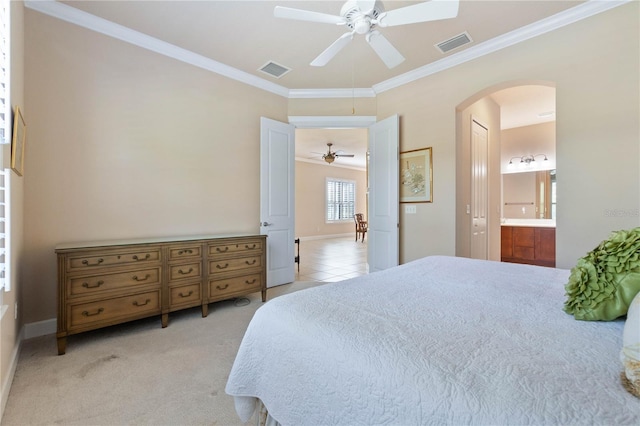 carpeted bedroom featuring connected bathroom, ceiling fan, and ornamental molding