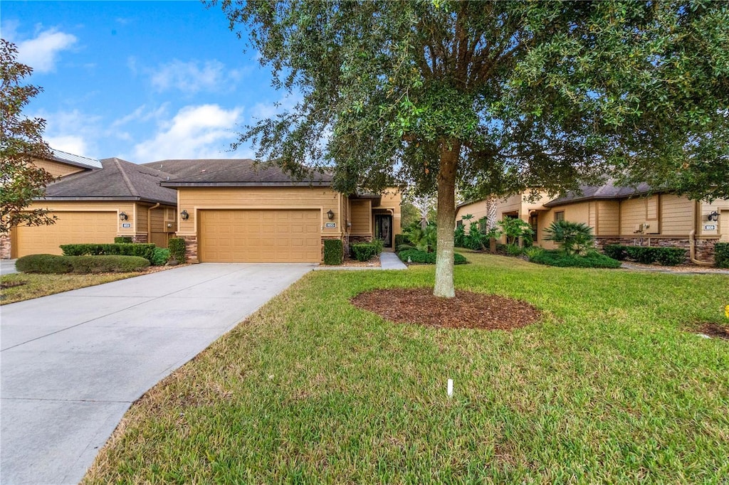 single story home featuring a garage and a front lawn