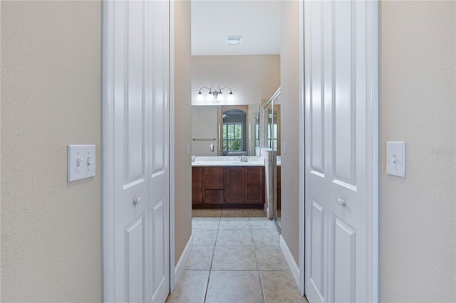 hall featuring sink and light tile patterned flooring