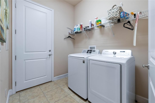 laundry area with washer and clothes dryer and light tile patterned floors