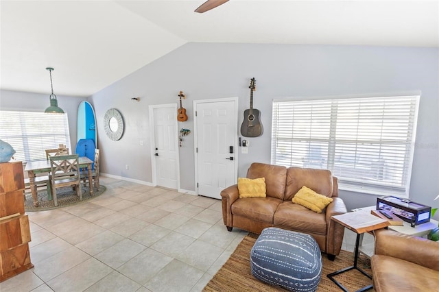 tiled living room with vaulted ceiling, ceiling fan, and plenty of natural light