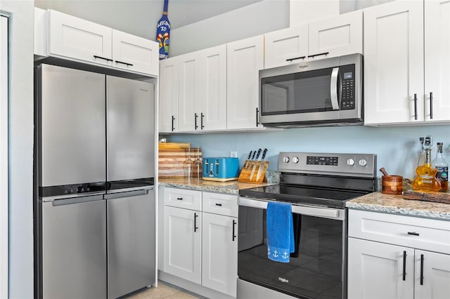 kitchen featuring light stone countertops, white cabinets, and stainless steel appliances