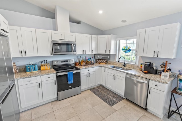 kitchen with white cabinets, vaulted ceiling, and appliances with stainless steel finishes