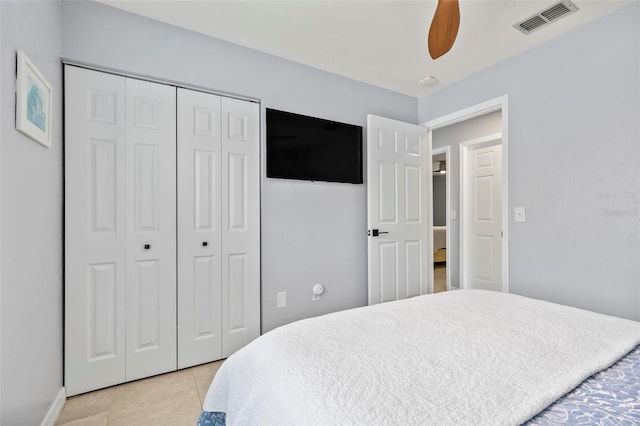 tiled bedroom featuring ceiling fan and a closet