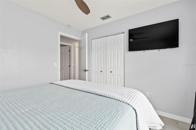 tiled bedroom featuring ceiling fan and a closet