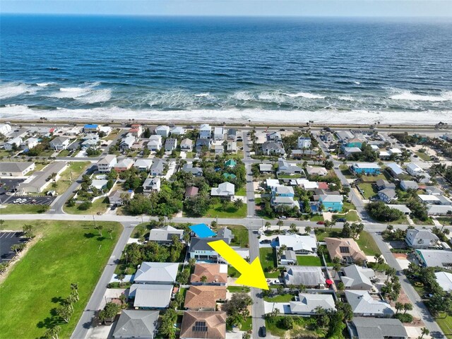 drone / aerial view featuring a beach view and a water view