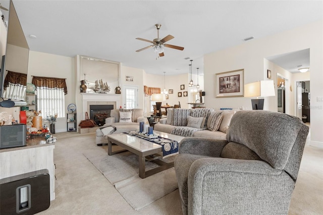 living room with light colored carpet, a healthy amount of sunlight, and a tile fireplace