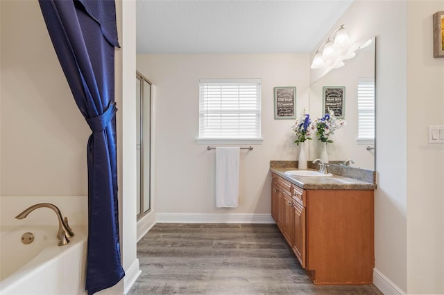 bathroom with vanity, hardwood / wood-style flooring, and plus walk in shower