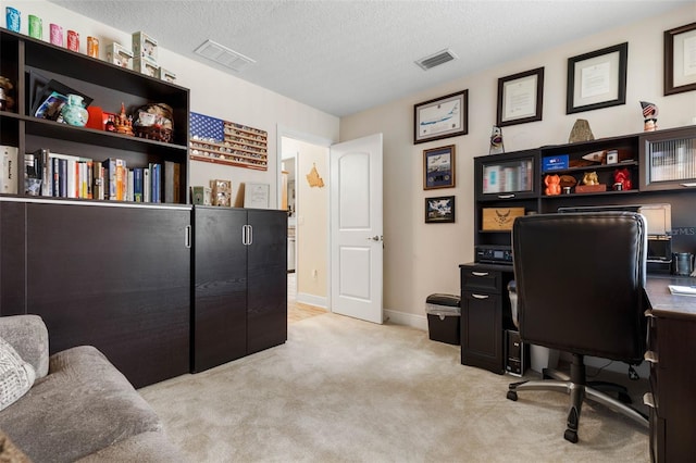 home office featuring light colored carpet and a textured ceiling