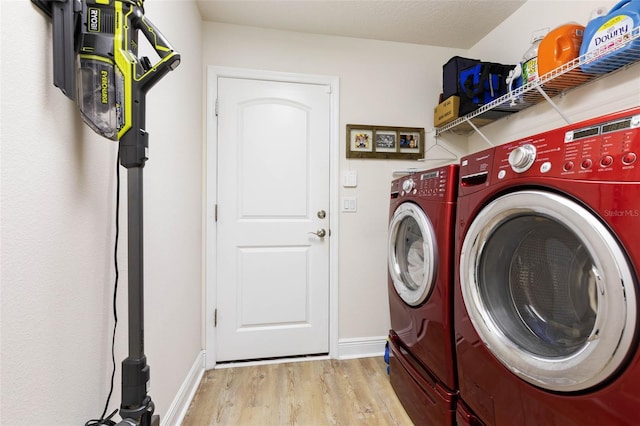 clothes washing area featuring separate washer and dryer and light hardwood / wood-style flooring