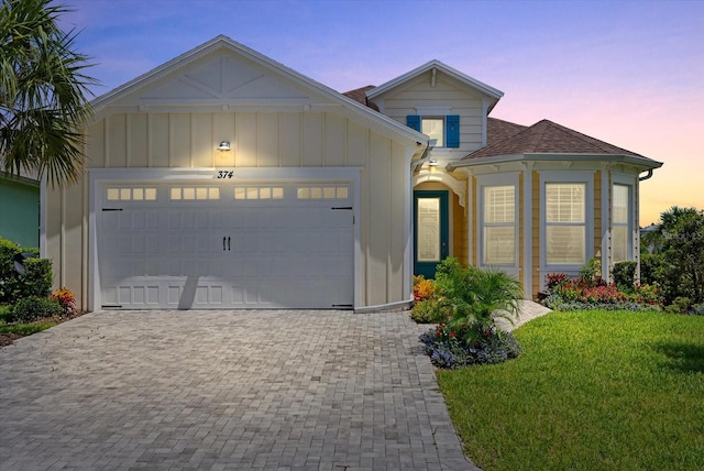 view of front of home featuring a garage and a yard