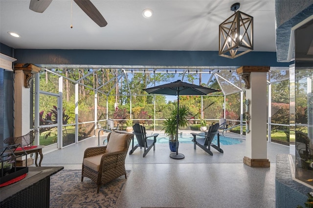 sunroom / solarium featuring ceiling fan and a swimming pool