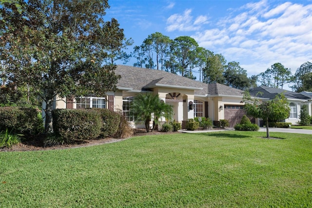 view of front of property featuring concrete driveway, a front lawn, an attached garage, and stucco siding