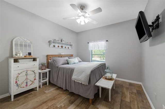 bedroom featuring ceiling fan, baseboards, and wood finished floors