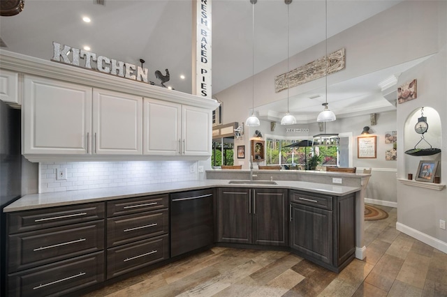 kitchen featuring dishwasher, light countertops, a sink, and white cabinets