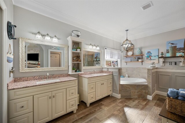 full bath featuring ornamental molding, wood finished floors, and a sink