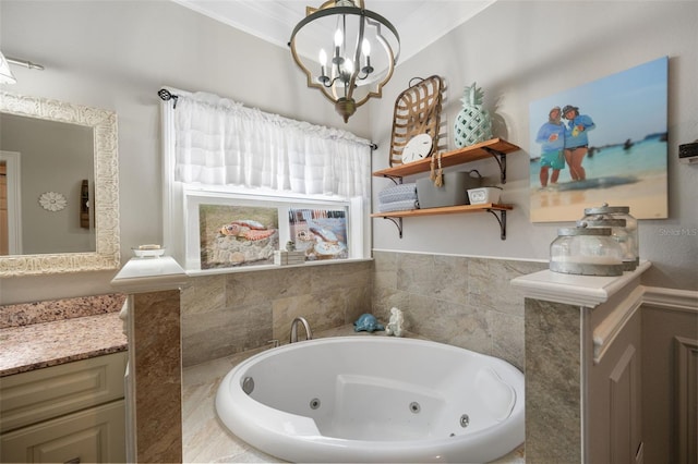 full bath featuring a tub with jets, vanity, and a notable chandelier