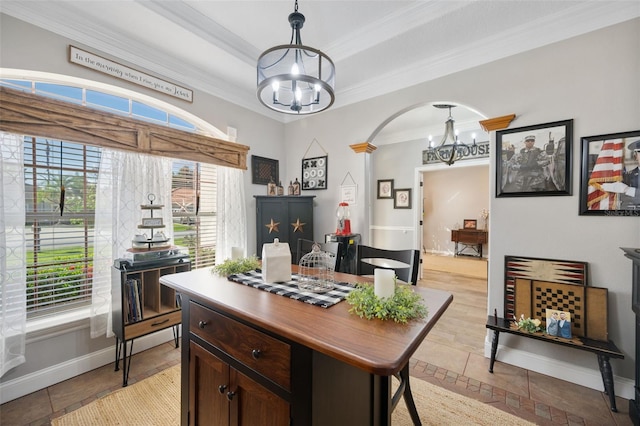 interior space featuring a chandelier, a tray ceiling, crown molding, and baseboards