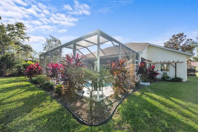 back of house with a lanai, stucco siding, a lawn, and a pergola