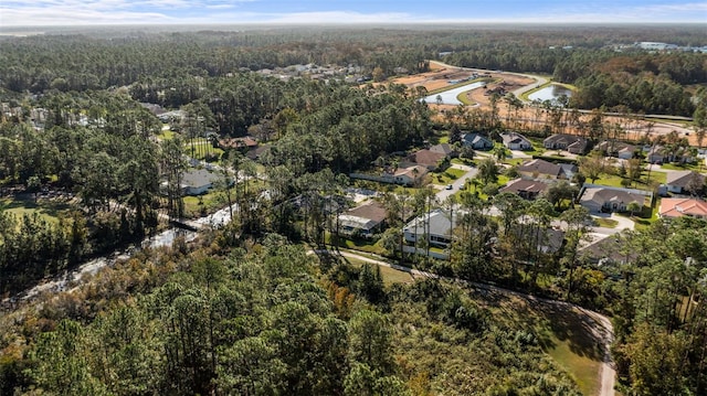 birds eye view of property featuring a residential view and a wooded view