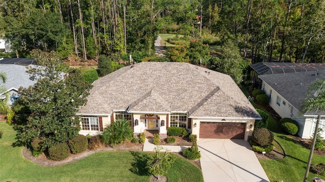 view of front facade with a garage, a shingled roof, concrete driveway, stucco siding, and a front lawn