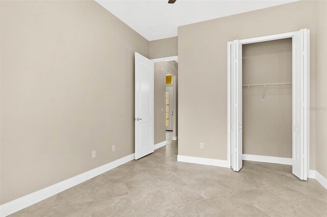 unfurnished bedroom featuring light tile patterned floors, ceiling fan, and a closet